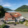 Hotel ResidenzWachau, © Niederösterreich Werbung / Maximilian Pawlikowsky Hotel ResidenzWachau am Flussufer mit umliegenden Hügeln.