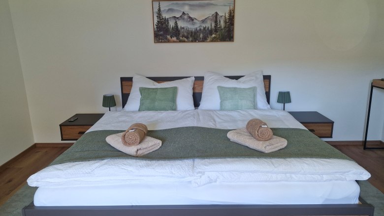 Dreimäderlhof, © Helga und Thomas Kraushofer Doppelbettzimmer Aloisia dekoriert mit grünen Kissen und Handtüchern