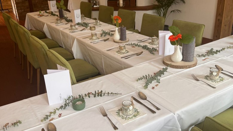 Elegantes Restaurant mit gedecktem Tisch, grünen Stühlen und Kamin.