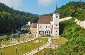 Historische Kartause Aggsbach in einer grünen, hügeligen Landschaft.
