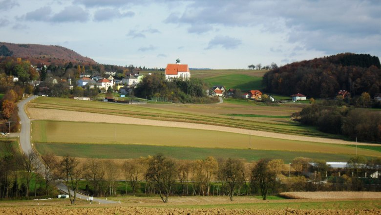 Landschaft mit Kirche und Feldern in Gerolding, Österreich.